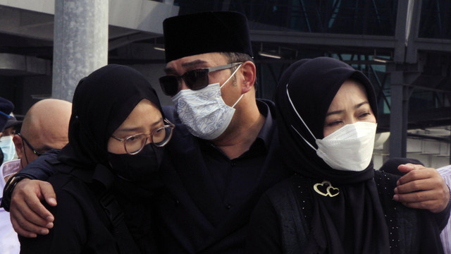 Gubernur Jawa Barat Ridwan Kamil (tengah) memeluk istrinya Atalia Praratya (kanan) dan putrinya Camillia Laetitia Azzahra (kiri) saat berada di kawasan kargo jenazah Bandara Soekarno Hatta, Tangerang, Banten, Minggu (12/6/2022). Foto: Muhammad Iqbal/ANTARA FOTO