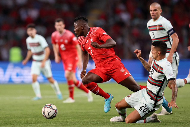 Pemain Timnas Swiss Breel Embolo berebut bola dengan pemain Timnas Portugal Joao Cancelo pada pertandingan lanjutan Grup B UEFA Nations League di Stade de Geneve, Lancy dekat Jenewa, Swiss. Foto: Denis Balibouse/REUTERS