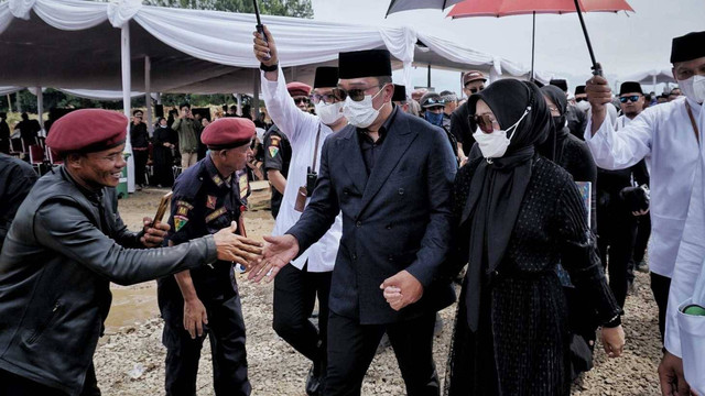 Gubernur Jawa Barat Ridwan Kamil dan Atalia menyapa dan menyalami warga yang datang ke pemakaman Eril usai menyelesaikan proses pemakaman di Cimaung, Banjaran, Kabupaten Bandung, Senin (13/6/2022). Foto: Jamal Ramadhan/kumparan