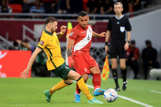 Pemain Timnas Peru Miguel Trauco berebut bola dengan pemain Timnas Australia Martin Boyle pada pertandingan Kualifikasi Piala Dunia 2022 Qatar di Stadion Al Rayyan, Al Rayyan, Qatar. Foto: Mohammed Dabbous/REUTERS