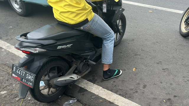Masyarakat sekitaran Stasiun Pasar Minggu, tidak memakai sepatu saat mengendarai motor, Rabu (15/6/2022). Foto: Haya Syahira/kumparan