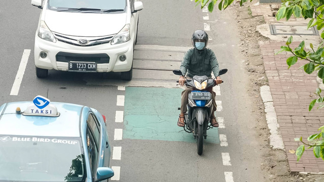Pengendara sepeda motor yang masih menggunakan sandal di Jakarta, Rabu (15/6/2022). Foto: Iqbal Firdaus/kumparan