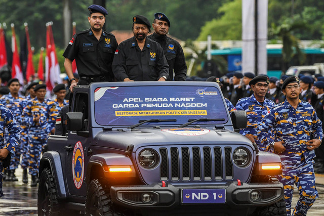Ketua Umum Partai NasDem Surya Paloh (tengah) didampingi Ketua Umum Garda Pemuda NasDem Prananda Surya Paloh (kiri) meninjau pasukan yang mengikuti Apel Siaga Baret di Parkir Timur Senayan, Kompleks Gelora Bung Karno, Jakarta, Rabu (15/6/2022). Foto: Galih Pradipta/Antara Foto