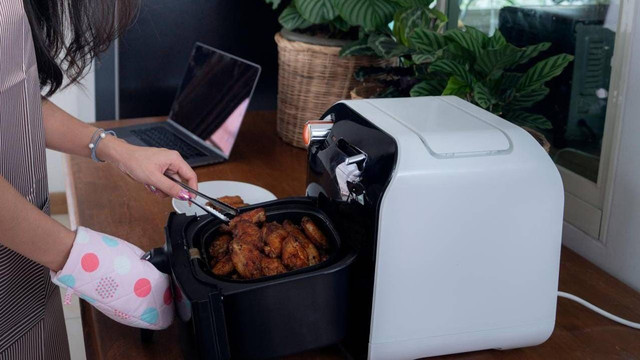 Seorang warga sedang memasak menggunakkan air fryer. Foto: istimewa