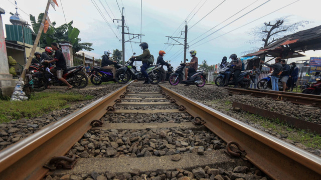 Pengendara motor melintas di perlintasan sebidang Kereta Api (KA) liar di Jalan Paseban, Bojong Gede, Kabupaten Bogor, Jawa Barat, Kamis (16/6/2022). Foto: Yulius Satria Wijaya/Antara Foto