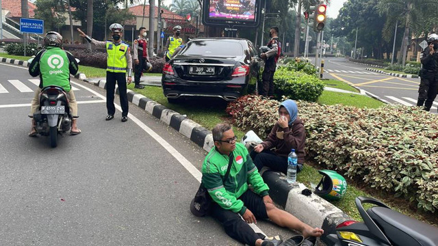 Ojol terduduk setelah terlibat kecelakaan dengan pengendara Mercy di SCBD, Jakarta, Jumat (17/6/2022) pagi.  Foto: Twitter/TMCPoldaMetroJaya