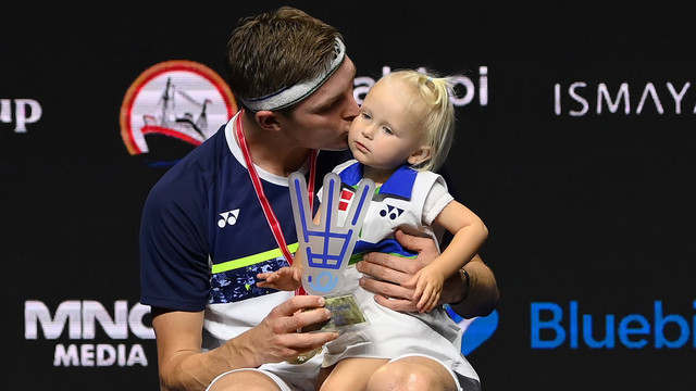 Pebulu tangkis tunggal putra Denmark Viktor Axelsen mencium anaknya di atas podium usai menjuarai final Indonesia Open 2022 di Istora Senayan, Jakarta, Minggu (19/6/2022). Foto: Sigid Kurniawan/Antara Foto