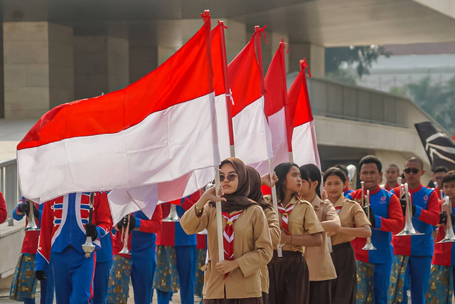Sejumlah peserta pawai budaya membawa bendera dan berjalan mengitari kawasan Taman Lapangan Banteng pada Rabu (22/6/2022). Foto: Iqbal Firdaus/kumparan