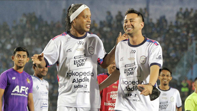 Mantan pesepak bola dunia asal Brasil Ronaldinho (kiri) berjalan dengan Chairman RANS Nusantara FC Raffi Ahmad saat membuka pertandingan Trofeo Ronaldinho di Stadion Kanjuruhan, Malang, Jawa Timur, Minggu (26/6/2022). Foto: Rizal Hanafi/Ds/Antara Foto