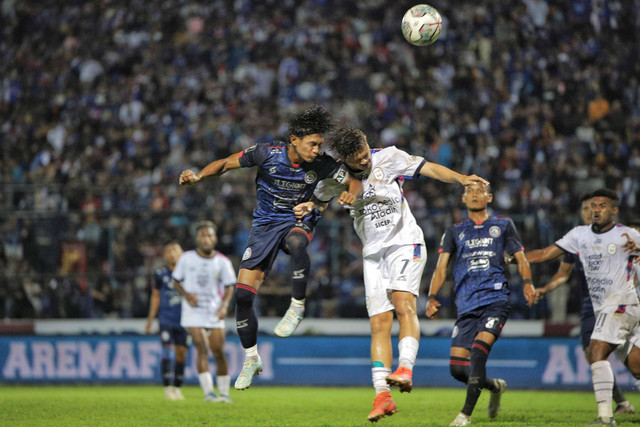 Pesepak bola Arema FC Johan Ahmad Farizi (kiri) berebut bola dengan pesepak bola RANS Nusantara FC Syamsir Alam (tengah) saat pertandingan Trofeo Nusantara di Stadion Kanjuruhan, Malang, Jawa Timur, Minggu (26/6/2022). Foto: Rizal Hanafi/Ds/Antara Foto