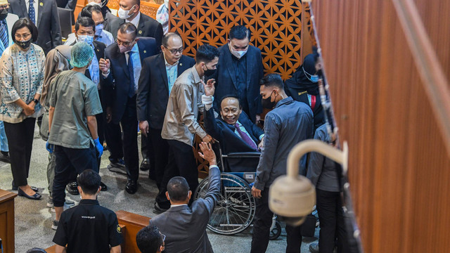 Wakil Ketua Badan Anggaran (Banggar) DPR Muhidin Muhammad Said (tengah) meninggalkan ruang paripurna menggunakan kursi roda usai terjatuh setelah memberikan laporan hasil pembahasan RAPBN 2023 kepada pimpinan di Rapat Paripurna DPR, Kamis (30/6). Foto: Galih Pradipta/ANTARA FOTO