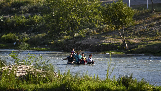 Sebuah keluarga migran dari Venezuela secara ilegal melintasi Sungai Rio Grande di Eagle Pass, Texas, di perbatasan dengan Meksiko pada 30 Juni 2022. Foto: Chandan Khanna / AFP