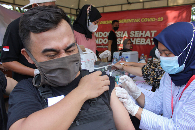 Petugas kesehatan menyuntikkan vaksin COVID-19 dosis penguat (booster) kepada warga di kawasan IRTI Monas, Jakarta, Selasa (5/7/2022). Foto: Agha Yuninda/ANTARA FOTO