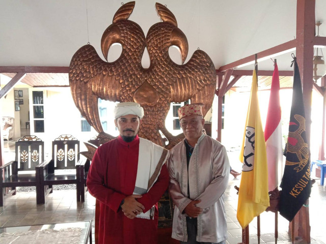Jo Qalem atau Imam Besar Kesultanan Hidayatussalam Sehan bersama Tuli Lamo Kesultanan Ternate Irwan Abd Gani, yang dilatari replika Burung Goheba Dopolo Romdidi sebagai lambang Kesultanan Ternate. Foto: Nurkholis Lamaau/cermat