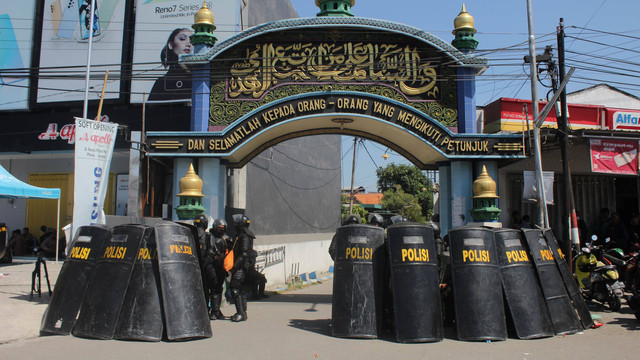 Polisi berjaga di depan gerbang Pondok Pesantren Shiddiqiyyah Ploso saat proses upaya penangkapan Moch Subchi Azal Tsani (MSAT) di Jombang, Jawa Timur, Kamis (7/7/2022). Foto: Syaiful Arif/Antara Foto