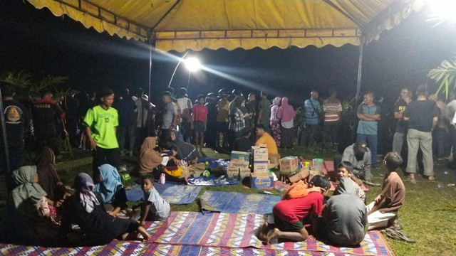 Keluarga korban dan warga duduk di bawah tenda saat mencari tiga orang kakak beradik yang hilang terseret arus sungai Krueng Meureubo, Aceh Barat. Foto: Dok. acehkini