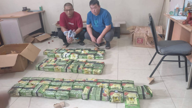 BARANG bukti sabu seberat 50 Kilogram dibungkus plastik teh diperlihatkan bersama diduga tersangka. 
