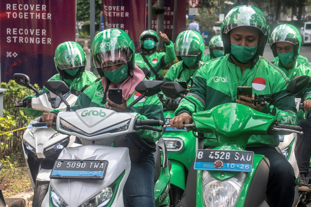 Pengemudi ojek daring kendaraan listrik GrabElectric menunggu calon pengguna di Jakarta, Selasa (12/7/2022). Foto: Muhammad Adimaja/ANTARA FOTO