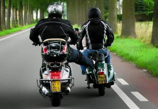 Pengendara sedang membantu mendorong motor yang mogok karena habis bahan bakar. Foto: dok. istimewa