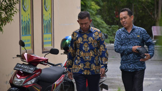 Kadis Ketahanan Pangan Donggala Najamudin Laganing (menunduk) di dampingi kuasa hukumnya hadiri panggilan penyidik. Foto: Jalu/ Tim PaluPoso