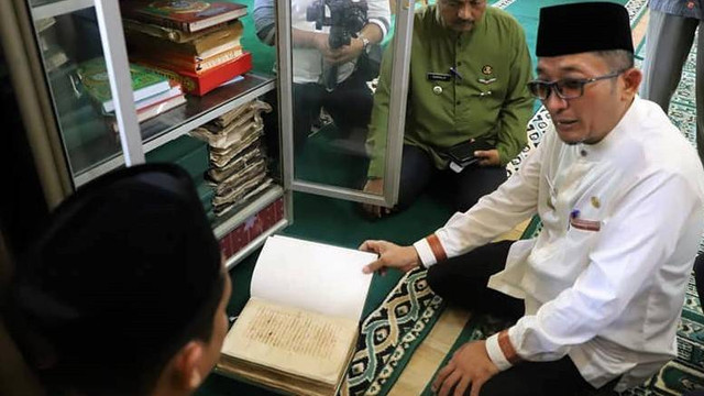 Wali Kota Padang Hendri Septa saat membuka kitab yang tersimpan di Surau Syekh Paseban. Foto: Humas