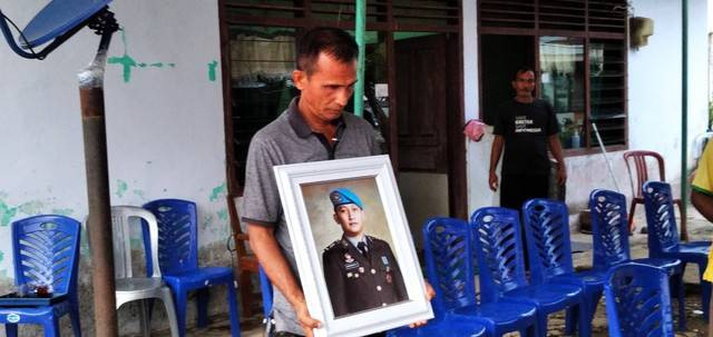 Samuel Hutabarat memegang foto anaknya, Brigadir Yosua/M Sobar Alfahri