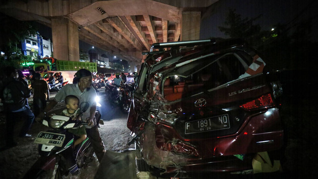 Sejumlah warga melihat kendaraan yang mengalami kerusakan akibat kecelakaan di Jalan Transyogi, Cibubur, Bekasi, Jawa Barat, Senin (18/7/2022).   Foto: Asprilla Dwi Adha/ANTARA FOTO