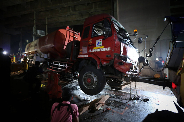 Petugas menggunakan mobil derek untuk mengangkat kepala truk pengangkut bahan bakar minyak (BBM) yang mengalami kecelakaan maut di Jalan Transyogi, Cibubur, Bekasi, Jawa Barat, Senin (18/7/2022).  Foto: Asprilla Dwi Adha/ANTARA FOTO