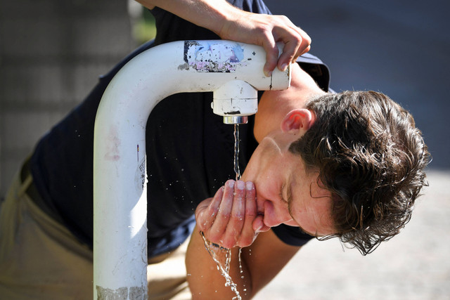 Seorang pria meminum air dari tempat minum umum selama gelombang panas di Nijmegen, Belanda 18 Juli 2022. Foto: REUTERS/Piroschka van de Wouw