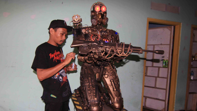 Khairul Mahmud saat merakit robot yang dibuat dari sampah plastik, di Kota Padang, Sumatera Barat, Selasa 19 Juli 2022. Foto: Ahmad/Langkan