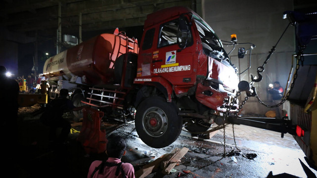 Petugas menggunakan mobil derek untuk mengangkat kepala truk pengangkut bahan bakar minyak (BBM) yang mengalami kecelakaan maut di Jalan Transyogi, Cibubur, Bekasi, Jawa Barat, Senin (18/7/2022). Foto: Asprilla Dwi Adha/ANTARA FOTO
