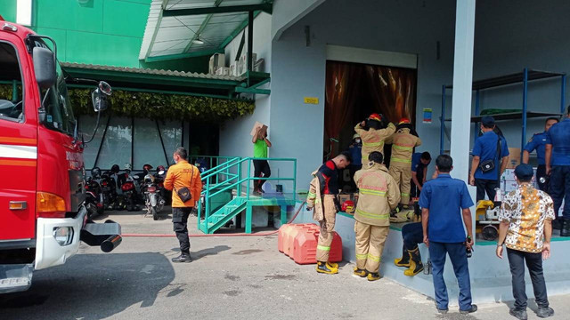 Petugas saat berupaya memadamkan kebakaran di ruang produksi pabrik minuman kesehatan Realfood, di Jalan Lettu Suyitno, Bojoneoro, Jawa Timur. Kamis (21/07/2022). (foto: dok istimewa)