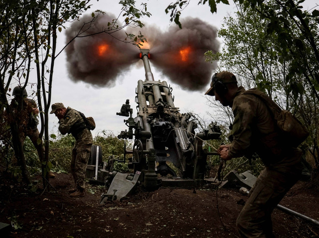 Anggota layanan Ukraina menembakkan peluru dari Howitzer M777 di garis depan, saat serangan Rusia di Ukraina berlanjut, di Wilayah Kharkiv, Ukraina 21 Juli 2022. Foto: REUTERS/Gleb Garanich