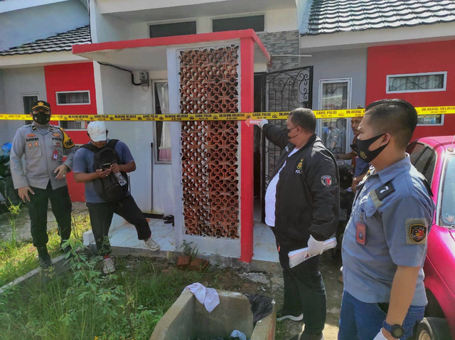 Petugas kepolisian saat melakukan olah TKP di lokasi pembunuhan. (ist)