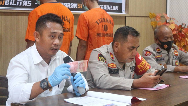 Banit 1 Pidum Satreskrim Polres Donggala, Bripka Moh Syarif M. Bakulu, saat memperlihatkan 1 lembar pecahan 100 ribu uang palsu yang diamankan dari pelaku pengedar uang palsu di Donggala, Sulawesi Tengah. Foto: Jalu/PaluPoso