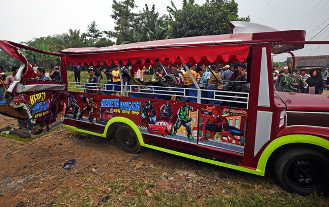 Warga melihat odong-odong yang ringsek tertabrak kereta api jurusan Merak-Rangkasbitung di Kampung Silebu Mesjid, Kragilan, Serang, Banten, Selasa (26/7/2022). Foto: Asep Fathulrahman/ANTARA FOTO