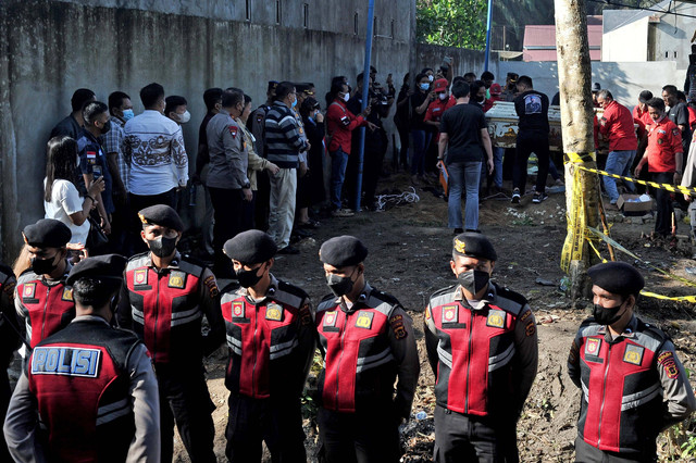 Sejumlah polisi berjaga saat pembongkaran makam almarhum Brigadir Polisi Nofriansyah Yosua Hutabarat atau Brigadir J di Sungai Bahar, Muarojambi, Jambi, Rabu (27/7/2022). Foto: Wahdi Septiawan/Antara Foto