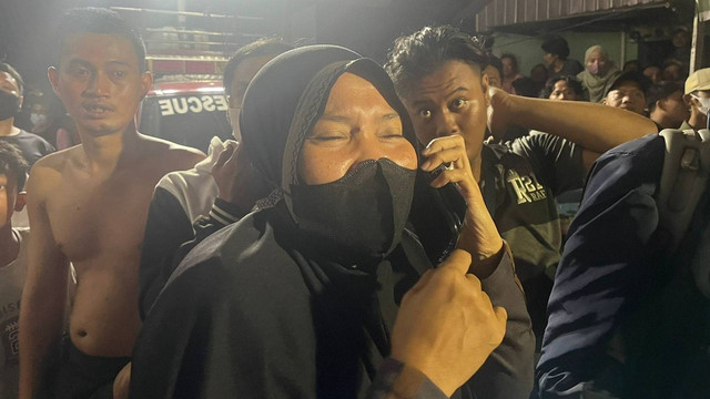 Warga histeris karena mengetahui adik iparnya terjebak di reruntuhan bangunan roboh di Jalan Rawa Sawah 2, Jakarta Pusat, Kamis (28/7/2022). Foto: Haya Syahira/kumparan