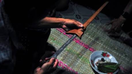 Waris perempuan memeriksa tambahan keris sebagai pusaka yang melengkapi "rukun yang lima", cincin dan sapu tangan dalam rangkaian pelaksanaan "gawai" (ritual pernikahan). Foto: Wahdi Septiawan/ANTARA FOTO