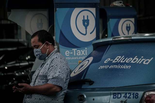 Pengemudi taksi Bluebird sedang menunggu saat mengisi daya untuk taksi listriknya di tempat pengisian daya baterai di Blue Bird Group, Mampang, Jakarta Selatan, Rabu (13/7/2022).  Foto: Jamal Ramadhan/kumparan
