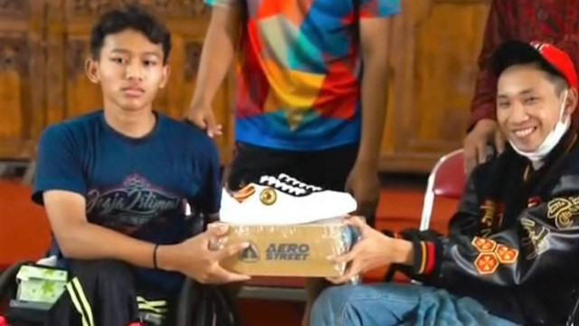 Komika Dani Aditya menyerahkan sepatu edisi terbatas ASEAN Para Games kepada penyandang disabilitas di YPAC Solo. FOTO: Dok Istimewa
