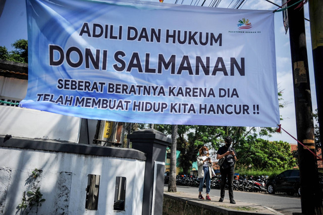 Warga berjalan di samping spanduk untuk terdakwa kasus penipuan investasi opsi biner Quotex Doni Salmanan yang tengah menjalani sidang dakwaan di Pengadilan Negeri Bale Bandung, Kabupaten Bandung, Jawa Barat, Kamis (4/8/2022). Foto: Raisan Al Farisi/ANTARA FOTO