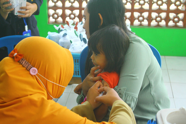 Bidan Desa Sebanen sedang melakukan suntik imunisasi MR. Dokumentasi pribadi.jpg