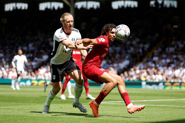 Pemain Liverpool Trent Alexander-Arnold beraksi bersama pemain Fulham Tim Ream di Stadion Craven Cottage, London, Inggris, Sabtu (6/8/2022). Foto: Action Images via Reuters/Peter Cziborra