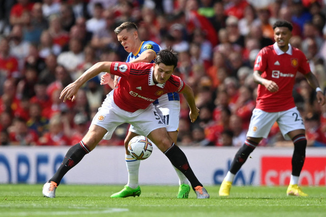 Pemain Manchester United Harry Maguire berebut bola dengan pemain Brighton & Hove Albion pada pertandingan Liga Inggris di Old Trafford, Manchester, Inggris. Foto: Toby Melville/REUTERS
