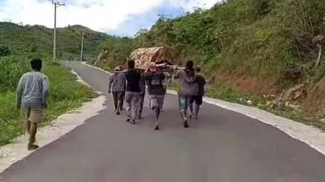 Warga menandu jenazah seorang lansia di Kecamatan Kalumpang, Mamuju, sejauh 13 kilometer karena tidak diizinkan menggunakan ambulans. Foto: Tangkapan Layar Video