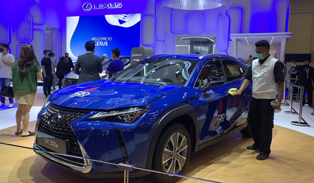 Seorang petugas tengah mengelap body Lexus UX 300e dengan seragam Official Car KTT G20 yang dipamerkan di GIIAS 2022.  Foto: Gesit Prayogi/Kumparan.com