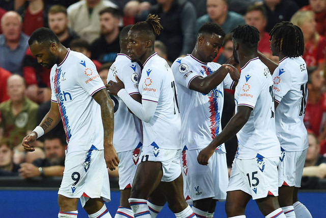 Pemain Crystal Palace Wilfried Zaha merayakan mencetak gol pertama mereka dengan rekan satu tim di Anfield, Liverpool, Inggris. Foto: Peter Powell/Reuters