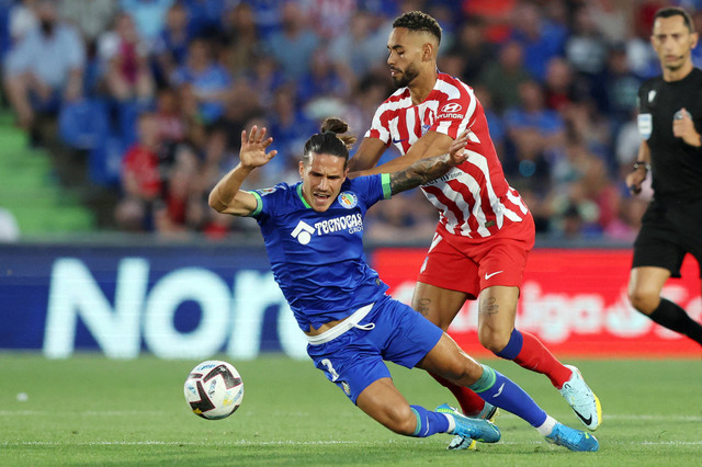 Gelandang Getafe Spanyol Jaime Seoane (kiri) bersaing dengan bek Atletico Madrid Brasil Renan Lodi selama pertandingan sepak bola liga Spanyol antara Getafe CF dan Club Atletico de Madrid di stadion Alfonso Perez Coliseum di Getafe. Foto: Thomas Coex/AFP