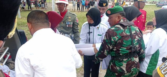Anggota TNI mengevakuasi para Paskibraka saat pingsan usai pengibaran bendera merah putih dalam HUT RI ke 77 di Kabupaten Pulau Taliabu, Maluku Utara. Foto: La Ode Hizrat Kasim/cermat